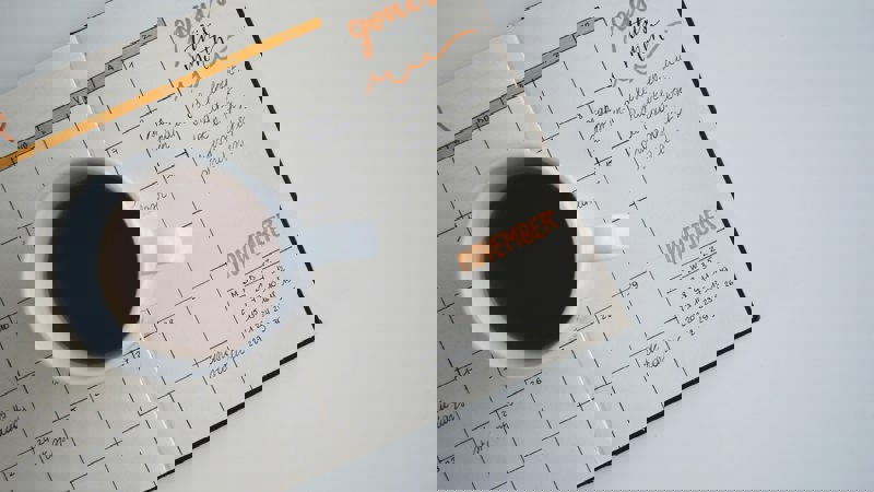 A mug of coffee sitting on a hand written calender/diary which says 'things to do'