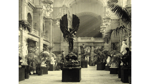 black and white image of museum centre hall with ornate features and a marble statue in the centre