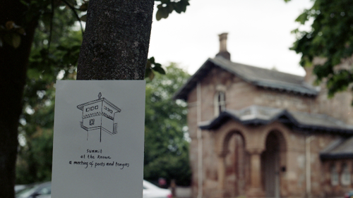 A sign is attached to a tree it reads "summit at the knowe a meeting of poets and tongues".