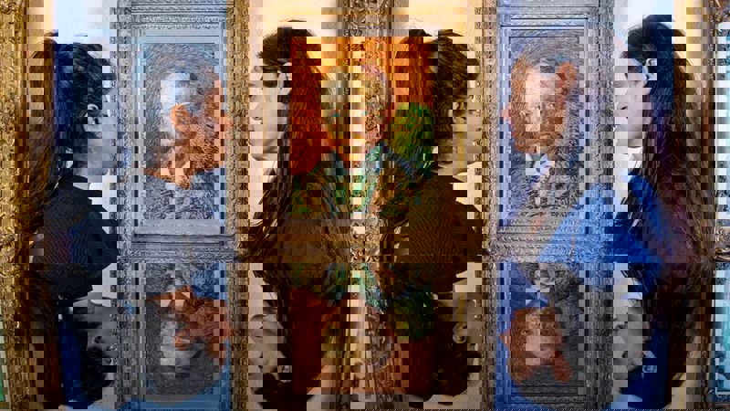 Photograph showing two young women standing looking at a Van Gogh painting hanging on a museum wall