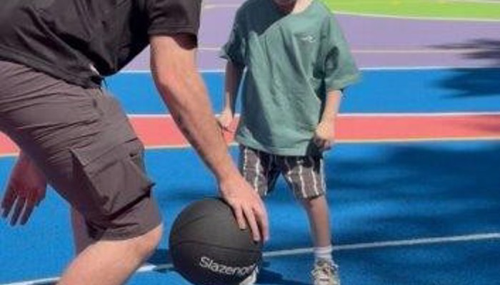 Adult and child playing basketball.