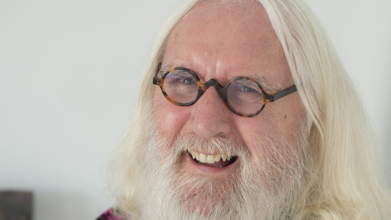 Billy Connolly laughing wearing a colourful shirt