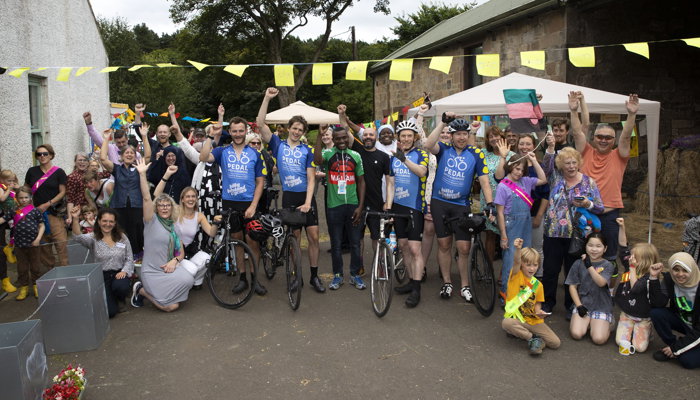A group of adults some with bikes stand for a group photos smiling 