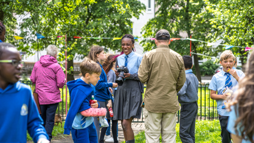 School children in Elcho park celebrate a new community mural, they are laughing and taking photos. 