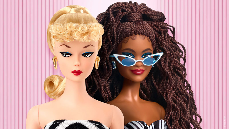 Two Barbie dolls side by side. One has blonde hair in curls and a ponytail, gold hoop earrings, and a black-and-white striped strapless dress. The other has long brown braided hair, blue earrings, white cat-eye sunglasses, and a black-and-white patterned strapless dress.