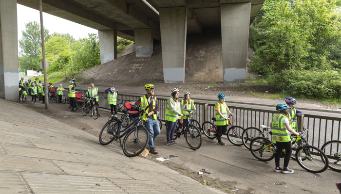 A group of young children on bikes are escorted through Glasgow M8.