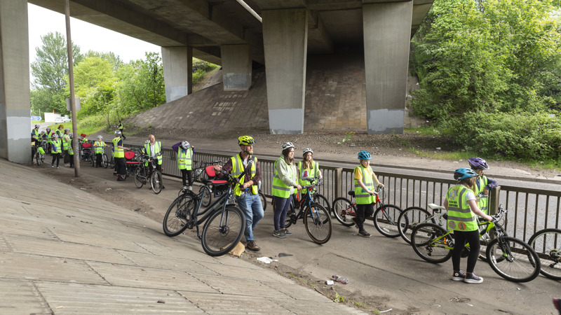 A group of young children on bikes are escorted through Glasgow M8.