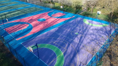 Multicoloured basketball and netballs painted blue, pink, purple and green