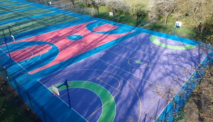 Multicoloured basketball and netballs painted blue, pink, purple and green