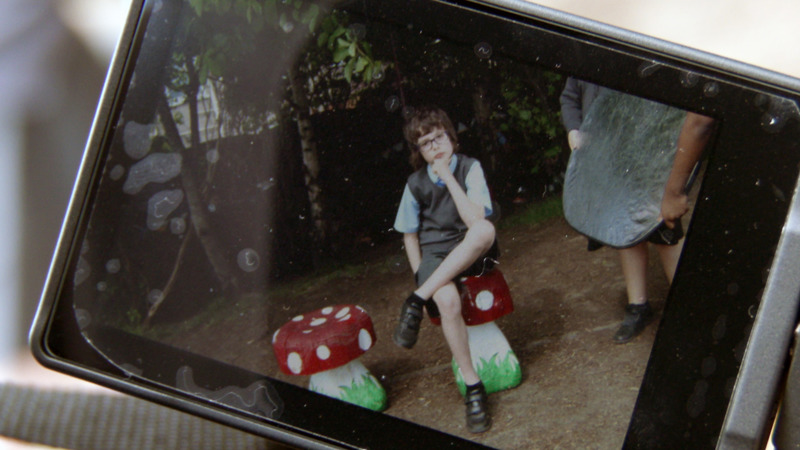 Someone shows an photograph of a primary school child prosing seriously on a phone screen. 