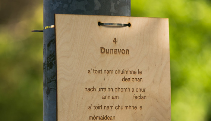 A signpost made of wood with a qr code links people to poetry