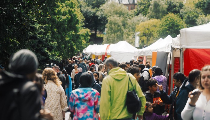 People browse market stalls offering food from around the world at a South Asian festival of music, dance and arts
