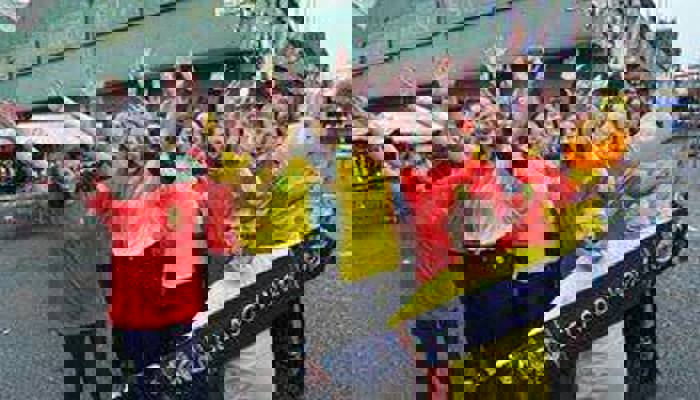 Andrew McVie holding a Glasgow 2014 scarf in front of a group of other volunteers during the Commonwealth Games.