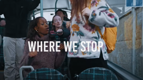 A still from a video showing four young friends sitting together and chatting on a bus