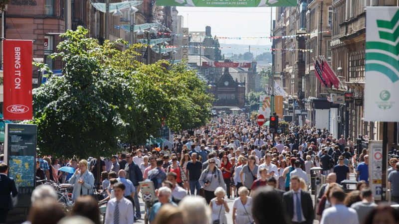 Large crowds of people walking down Buchanan Street on a sunny day during the Glasgow 2014 Commonwealth Games.