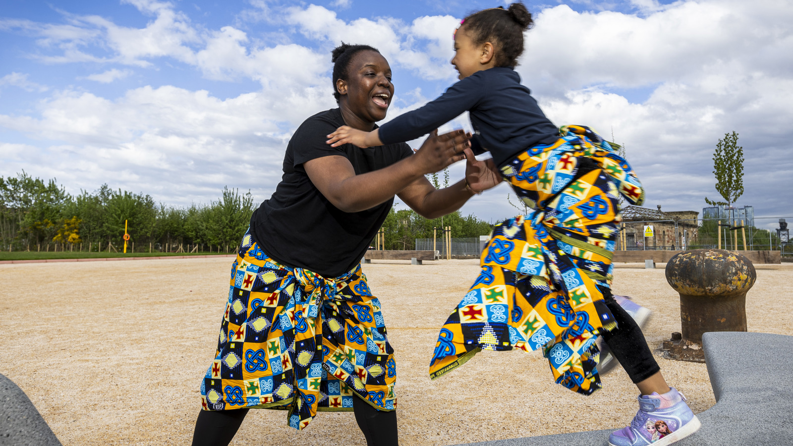 An adult and a child come together as part of a dance routine