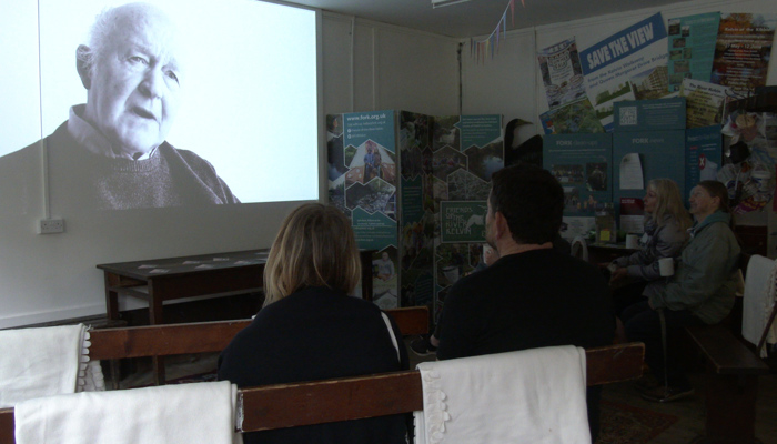 Two people watch a film in black and white. 