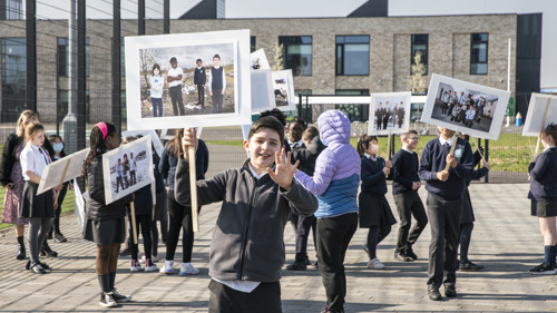 School children hold protest signs outdoors