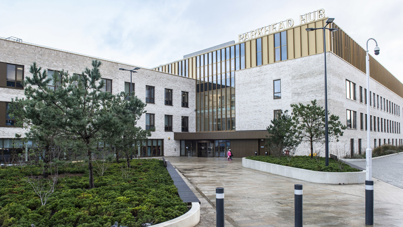 Greenery lines the path to the front of a health, social care and community facility